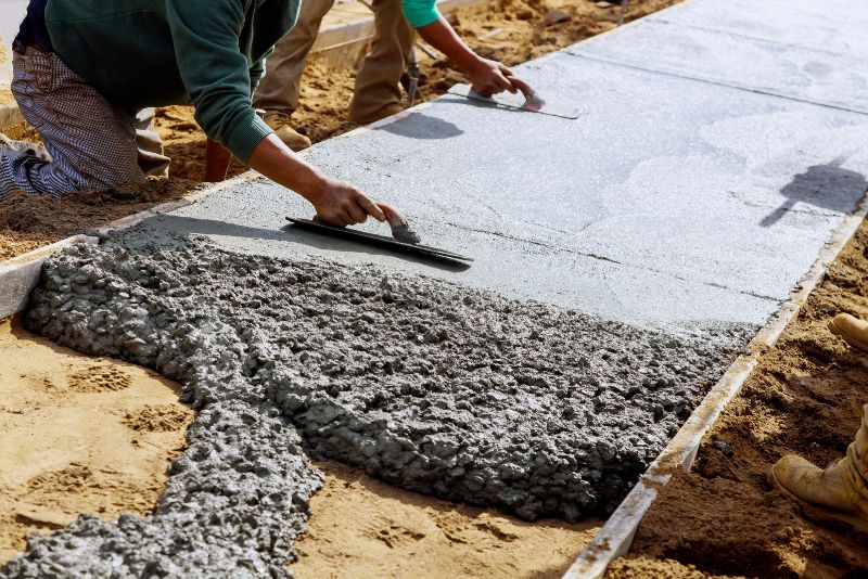 concrete sidewalk installed by two workers